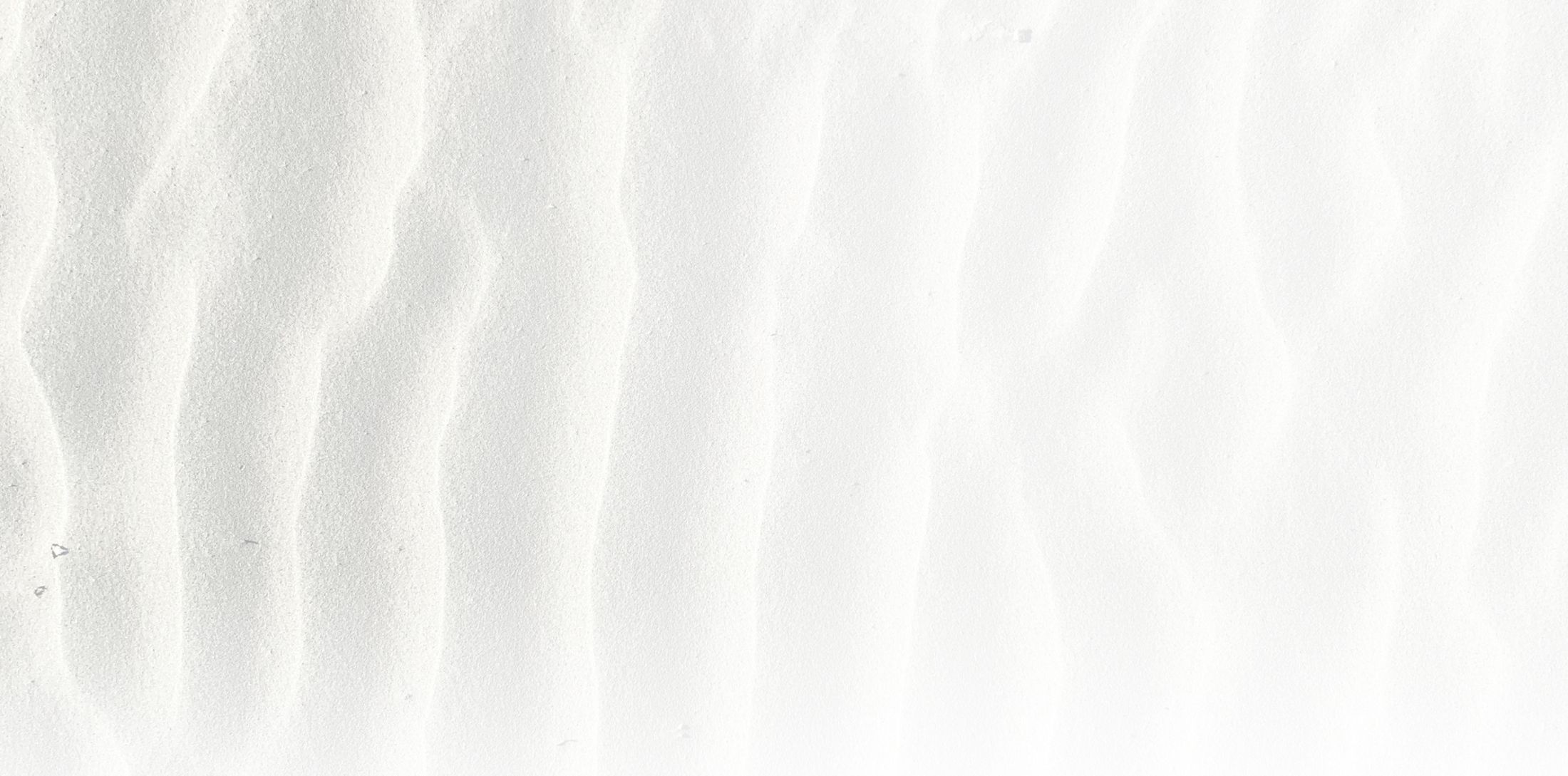 Textured white sand surface with gentle ripples.