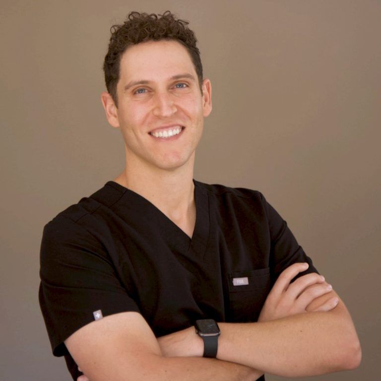 Smiling healthcare professional in black scrubs.