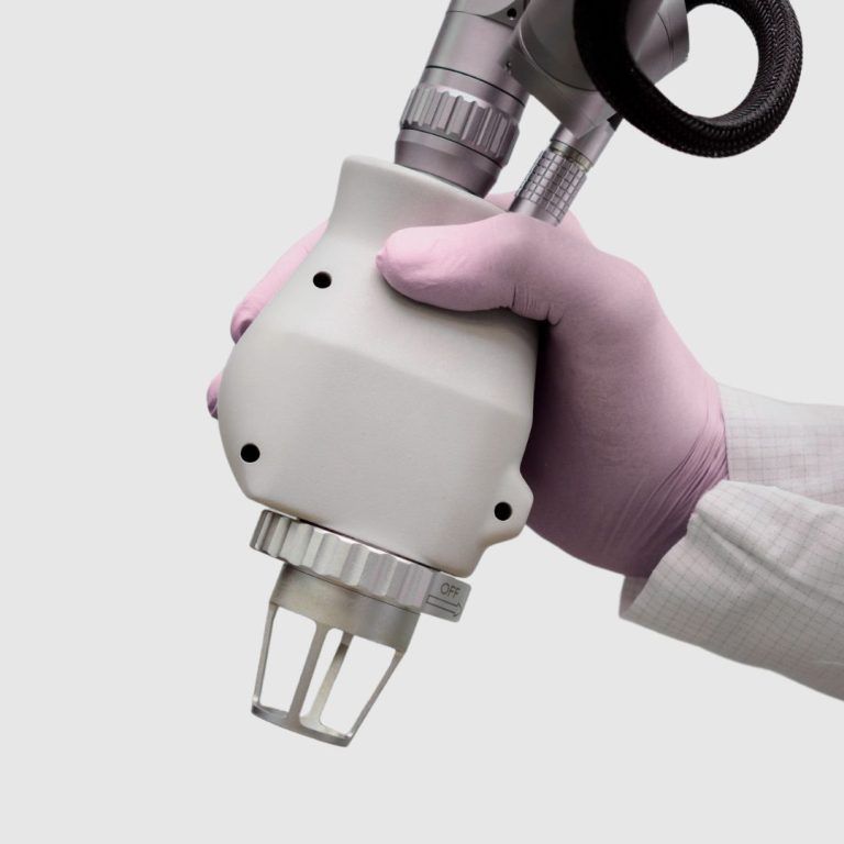 Medical device held by gloved hand.