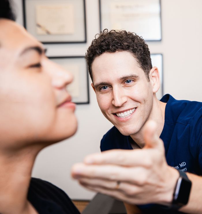 Newport Beach facial plastic surgeon consulting with patient in office setting.