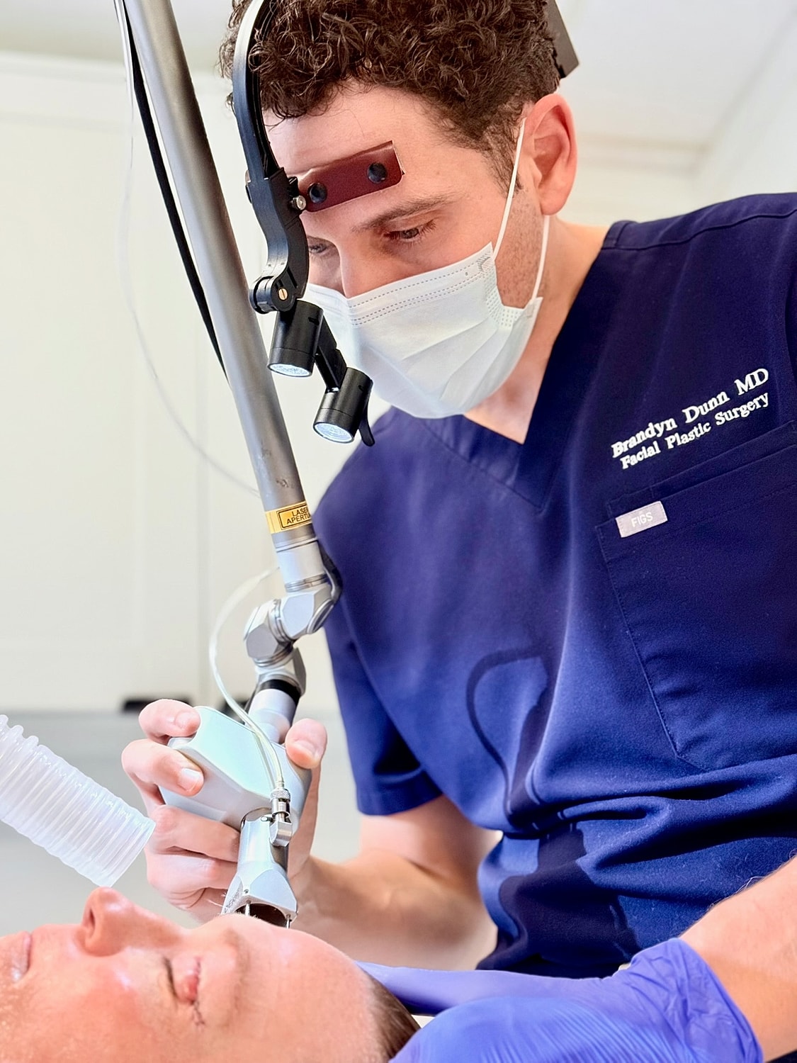 Person in pineapple-patterned shirt sitting indoors.