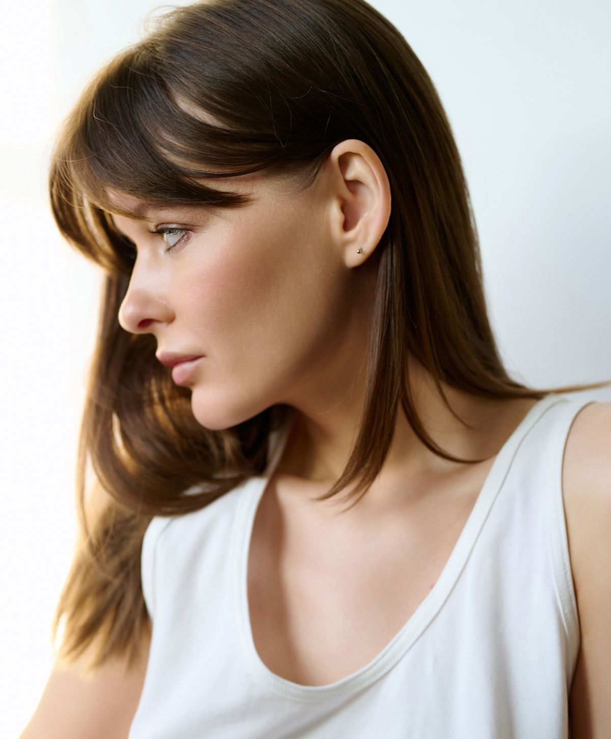 Profile of a Newport Beach otoplasty model with long brown hair.