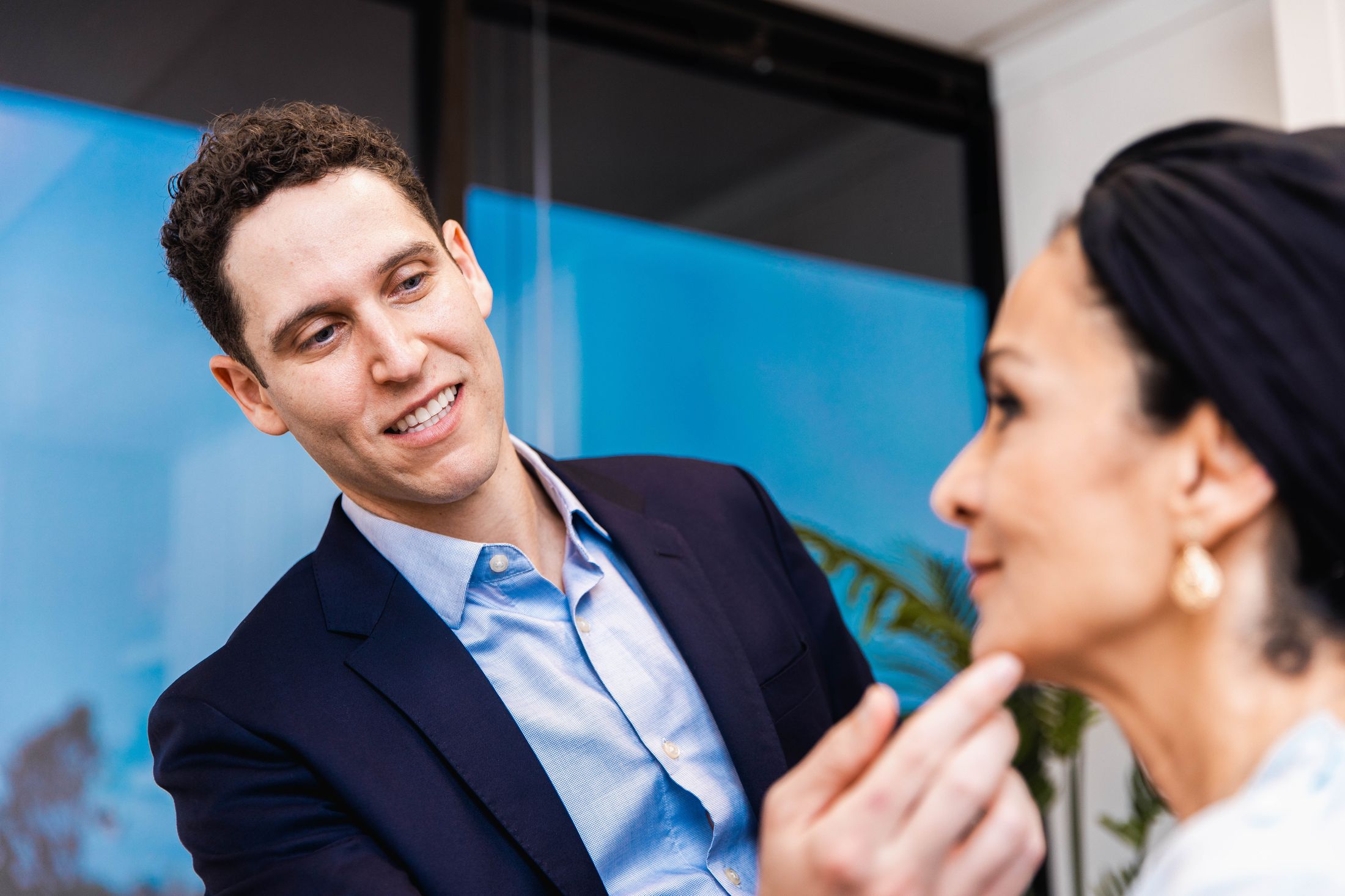 Newport Beach plastic surgeon consulting with woman in bright setting.