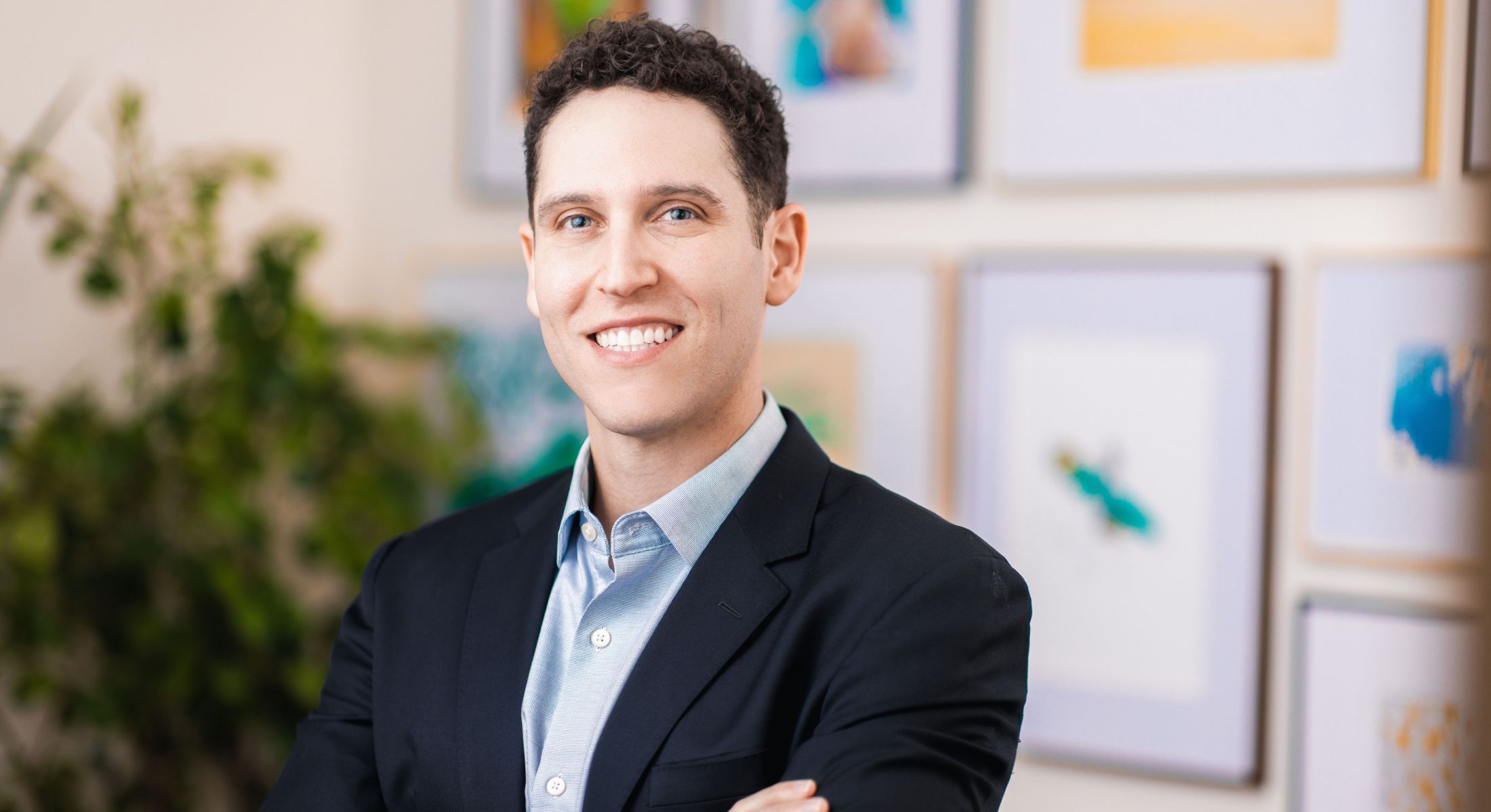 Smiling man in a suit against art background.