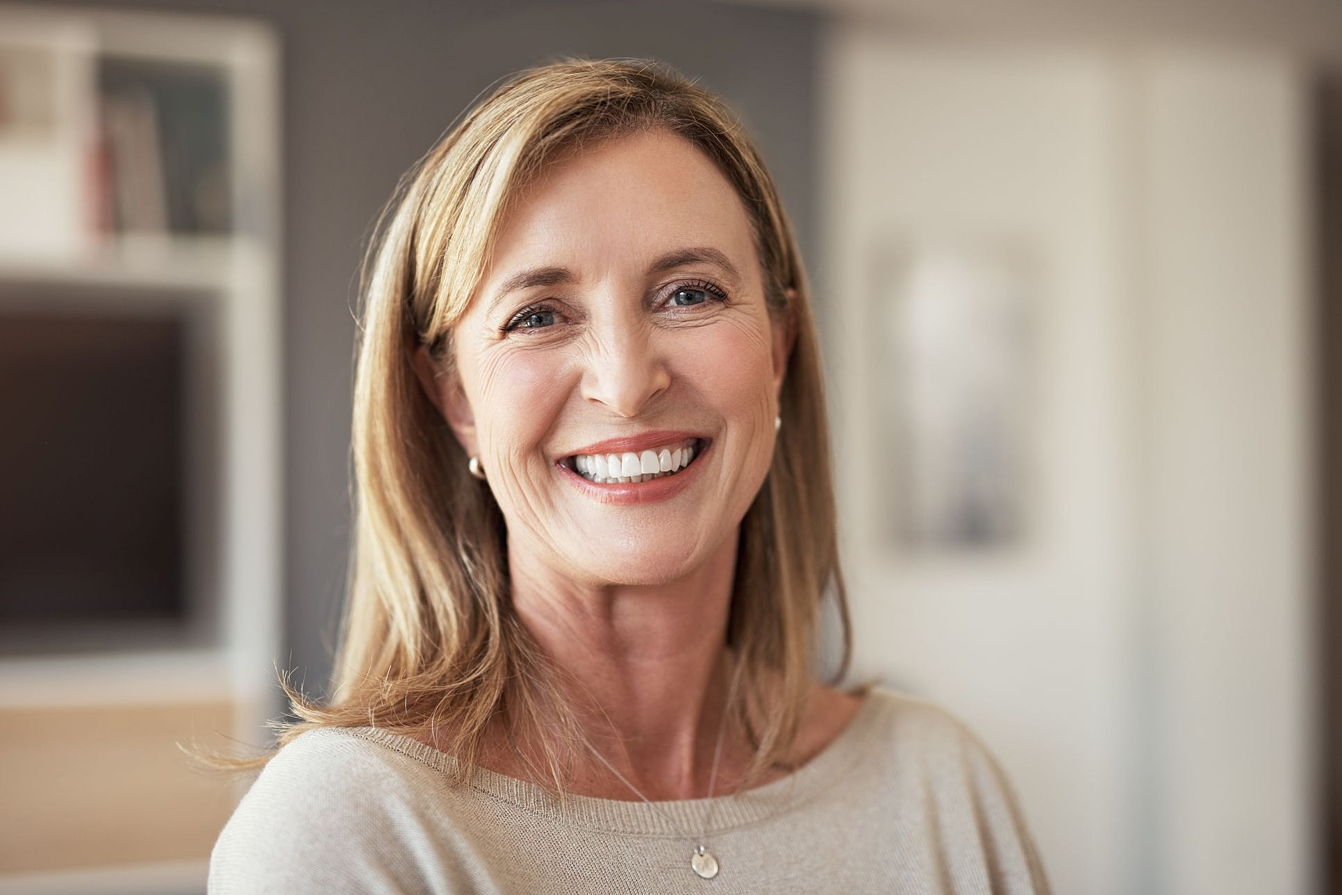 Smiling middle-aged woman with healthy, natural-looking skin and visible expression lines.