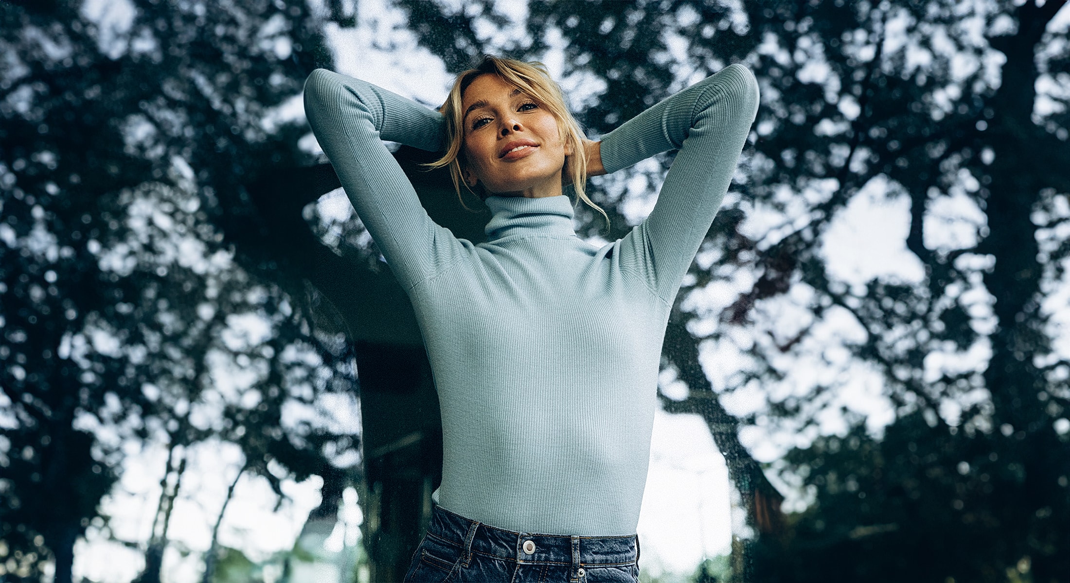 Smiling woman in a light blue sweater.